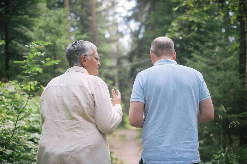 Zwei Personen laufen drau&szlig;en im wald und unterhalten sich