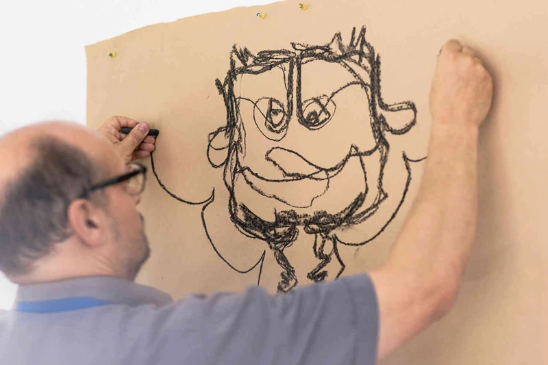 Mann malt eine Skizze von einem Gesicht